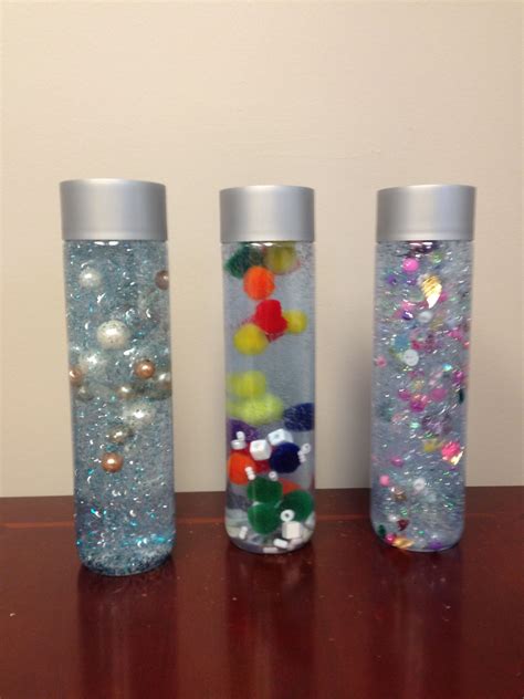 Three Glass Vases Filled With Different Types Of Beads And Confetti On