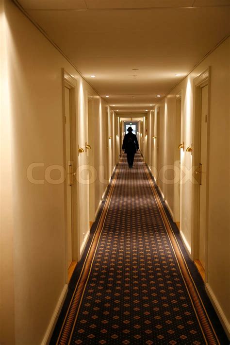 Black Dressed Person Walking Down A Long Hotel Corridor Motion Blur