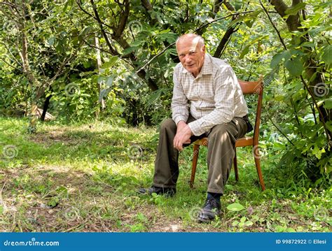 Senior Man Sitting On A Chair In The Garden Stock Photo Image Of