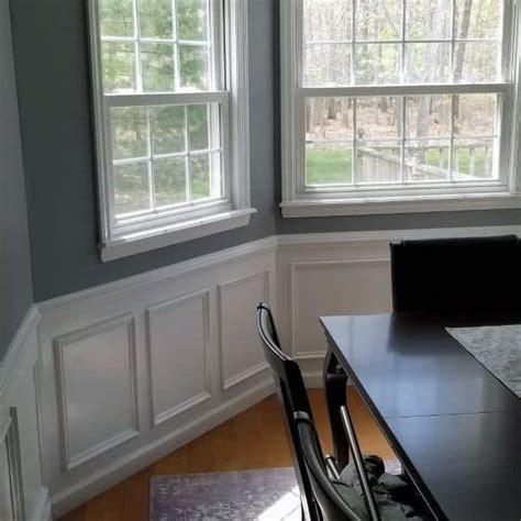 An arteriors analise chandelier hangs over wood top dining table surrounded by dark gray leather dining chair s and seating white slipcovered head chair s. Top 70 Best Chair Rail Ideas - Molding Trim Interior Designs