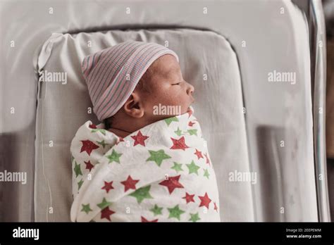 Newborn Baby Boy In Bassinet Wrapped In Hospital Blanket With Hat Stock