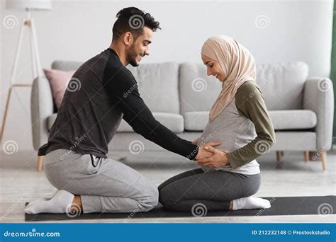 Caring Arab Husband Making Neck Massage To Pregnant Muslim Wife At Home