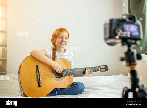 Portrait Of Beautiful Cute Caucasian Child Girl Blogger Playing Guitar