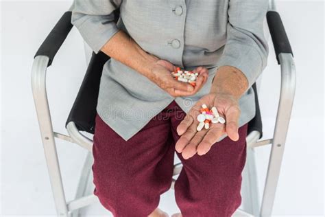 Pills In Hand Senior Woman Sitting On Chair And Holding Pill I Stock