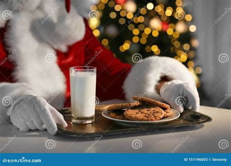 Santa Claus Eating Cookies And Drinking Milk At Table Closeup Stock