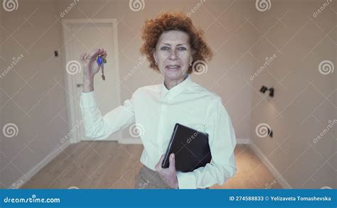Elderly Female Real Estate Agent Holds Keys To New Apartment Mature