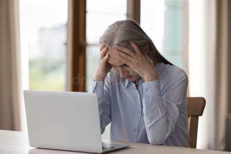 older businesswoman looks at laptop hold head looks desperate stock image image of older head