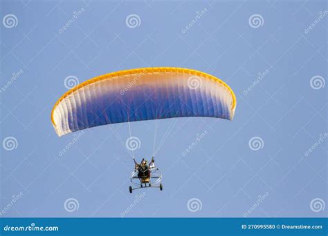 Paraglider With Engine Is Flying In The Blue Sky Stock Photo Image