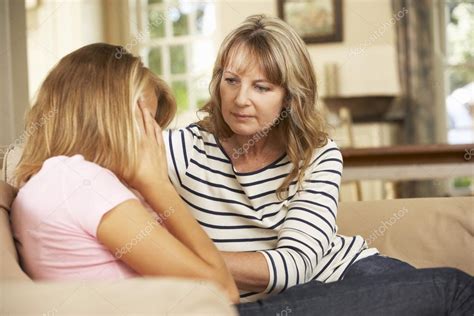 Mother Comforting Teenage Daughter At Home Stock Photo By