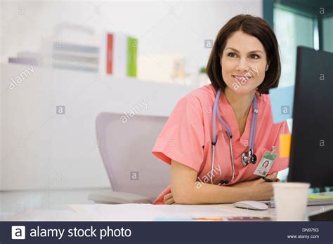 Female Nurse Sitting At Desk Stock Photo Alamy
