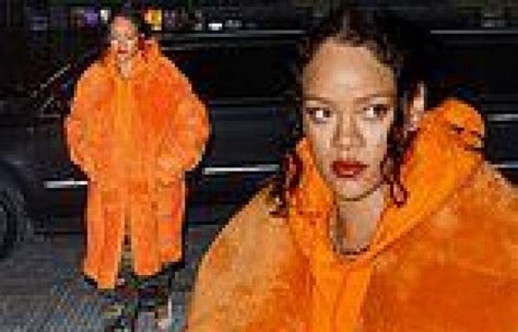 Rihanna Rocks A Bold Orange Coat And A Matching Hoodie While Taking A