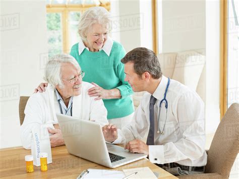 Doctor Speaking With Older Patients At House Call Stock Photo Dissolve