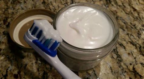 A Toothbrush Sitting Next To A Jar Of Cream