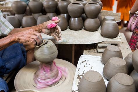 Premium Photo Dirty Hands Making Pottery In Clay On Wheel