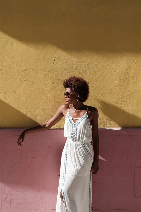 beautiful african female model posing in front of colorful wall by stocksy contributor brkati