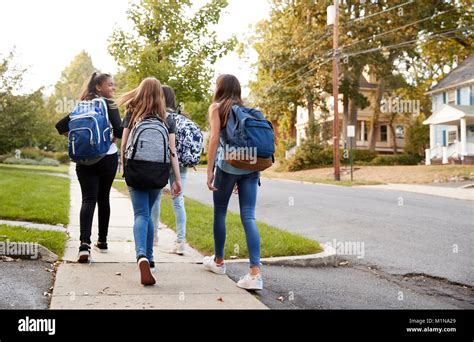 Four Young Teen Girls Walking To School Together Back View Stock Photo