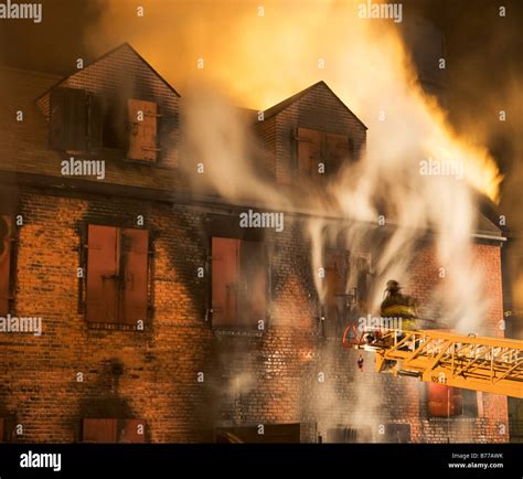 Firefighter On Crane Fighting Building Fire Stock Photo Alamy