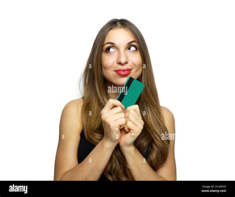 Pleased Intrigued Brunette Woman In Black Dress Holding Credit Card And Looking Away Over White