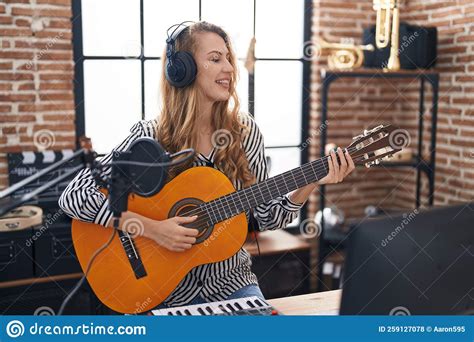 Young Blonde Woman Musician Playing Classical Guitar At Music Studio