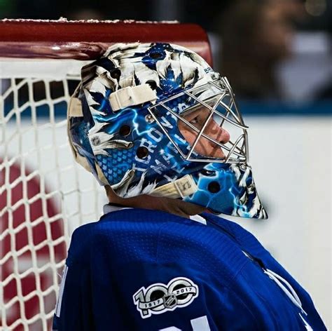 A Hockey Goalie Wearing A Mask On His Head And Looking At The Net In