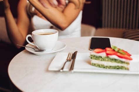 Belle Femme De Race Blanche Aux Longs Cheveux Blonds Ondulés Est Assise Sur Le Canapé Boit Du