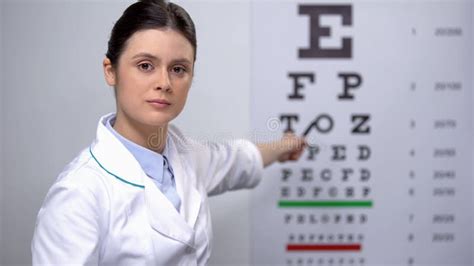 Professional Female Optometrist Showing Letters On Eye Chart Sight