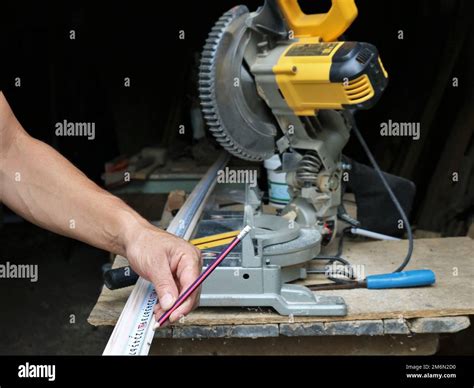 Working With A Miter Saw And Wood Planks Measuring The Right Length Of