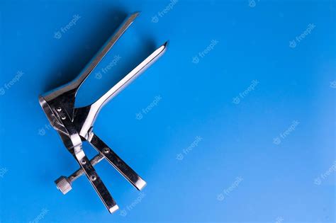 premium photo vaginal speculum for examination by a gynecologist on a blue background