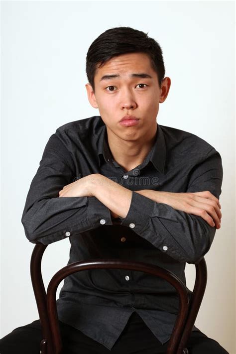 Lustiger Junger Asiatischer Mann Der Seine Zunge Zeigt Und Kamera Betrachtet Stockbild Bild