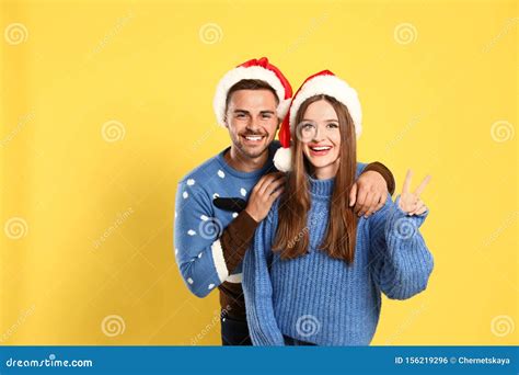 pareja con sombreros de navidad y santa con fondo amarillo foto de archivo imagen de festivo