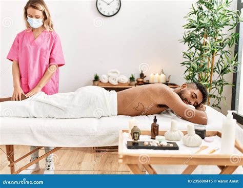 Masseur Woman Make Legs Massage To African American Man At Beauty