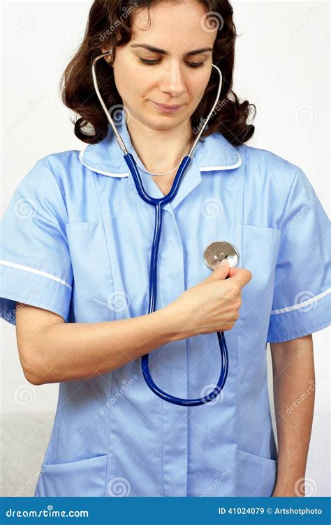 Young Female Doctor Checking Her Own Heart Beat Using A Stethoscope