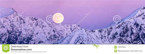 Full Moon Rising Over A Winter Mountain Landscape Stock