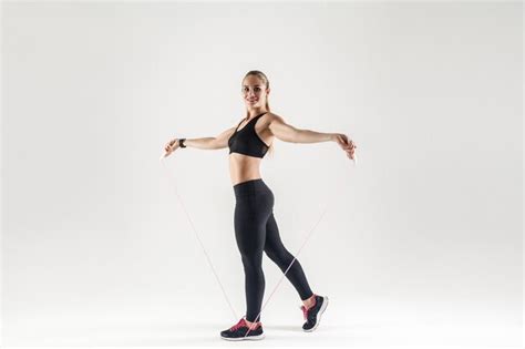 premium photo happy beautiful blonde woman holding skipping rope and toothy smiling at camera