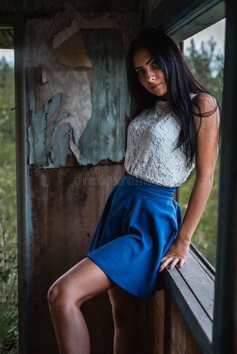 Young Adult Seductive Brunette In Blue Skirt And White Shirt Posing In