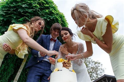 Premium Photo Newlyweds And Bridesmaids Have Fun And Eat Wedding Cake