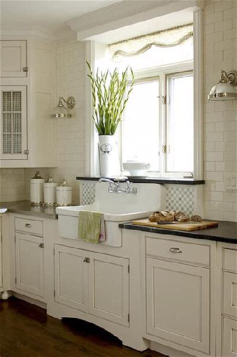 This plain kitchen design with white shaker cabinets with white quartz countertop, subway backsplash tiles, white central island, and light wood. Ceiling Height Tile - Traditional - kitchen - House & Home