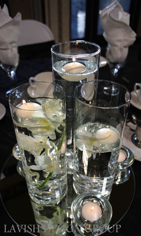 3 Cylinder Vases With Submerged Cream Orchids And Floating Candles