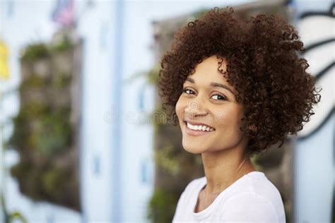 Outdoor Head And Shoulders Portrait Of Smiling Young Woman Stock Photo