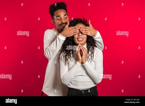 African Man Closes Eyes Of His Beloved Girlfriend Before Surprise Her Couple In White On Red