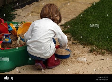 Little Girl Playing In A Sandpit Stock Photo Alamy
