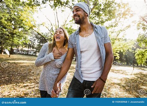 Portrait Of Romantic And Happy Mixed Race Young Couple In Park Stock