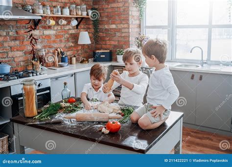 Modern Kitchen And Three Youth Boys Cooking Some Food Stock Image