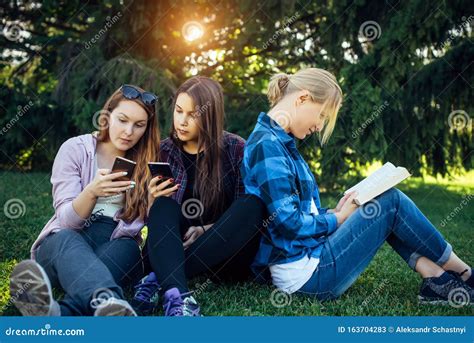 Drie Schattige Meisjes Ontspannen En Socialiseren Op Het Gras In Het Zomerpark Jonge Vrouwen Op