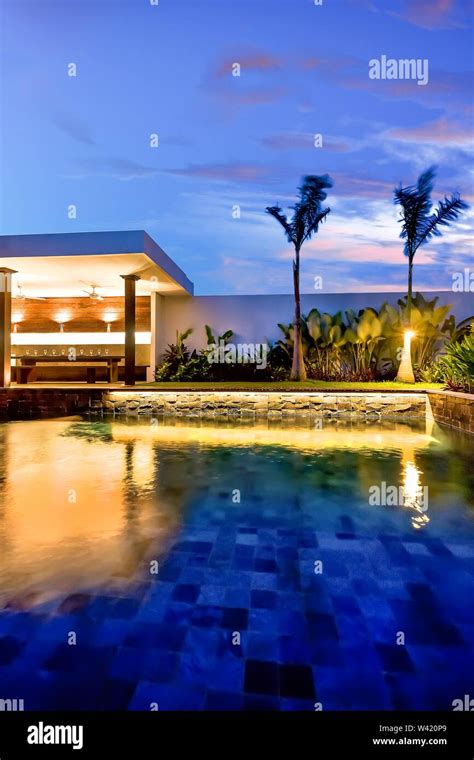 Luxury Water Pool And Garden With Dining Area Illuminates Using Lights