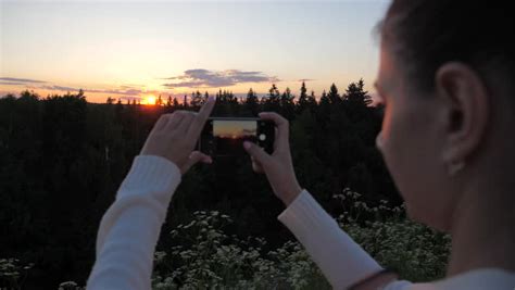 Woman Looking Back At Camera Holding A Smartphone Image Free Stock