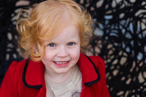 retrato de uma menina bonita com cabelo vermelho em um revestimento vermelho foto de stock