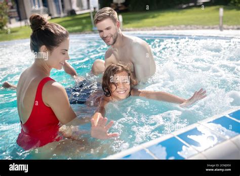 Happy Parents Teaching Their Son To Swim In The Pool Stock Photo Alamy