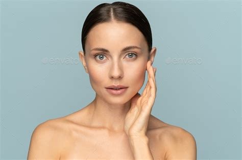 Woman With Natural Makeup Combed Hair Touching Well Groomed Pure Skin