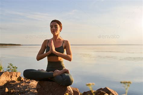 Beautiful Young Woman Meditating On The Beach Stock Photo By Iakobchuk